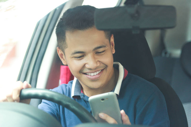 man using mobile phone while driving his car - Fotó, kép