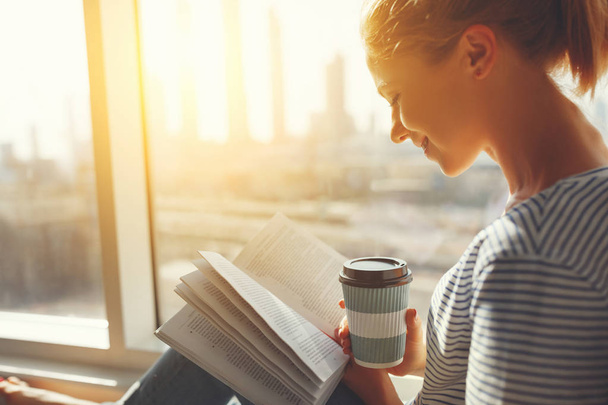 Счастливая молодая женщина читает книги и пьет кофе в постели
  - Фото, изображение