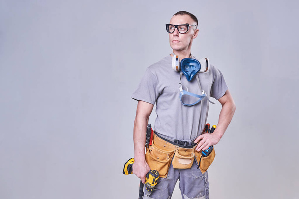 Master Builder-finisher in work clothes, with a drill screwdriver in hand - Photo, Image