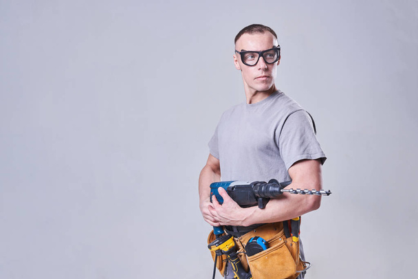 Master Builder-finisher w ubraniu roboczym, z perforatorem w rękach - Zdjęcie, obraz