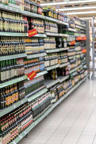 Different types of beer on the shelves in the supermarket - Photo, image