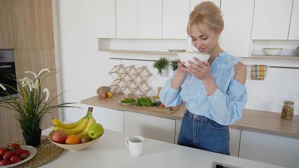 Elegante ragazza cucina in posa per la colazione al mattino, in piedi a
  - Foto, immagini