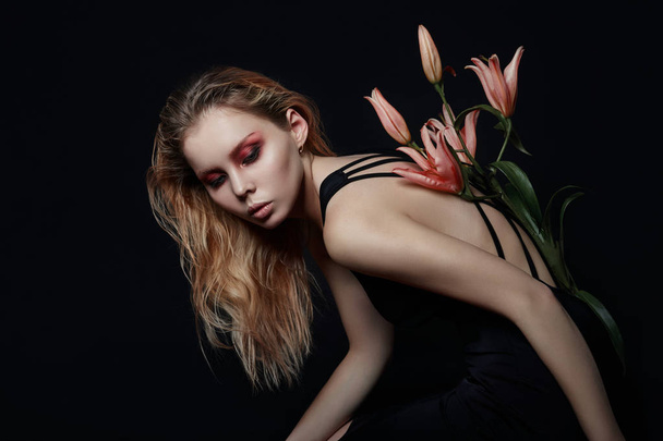 Art beauty girl with lilies behind on a black background. Creati - Zdjęcie, obraz