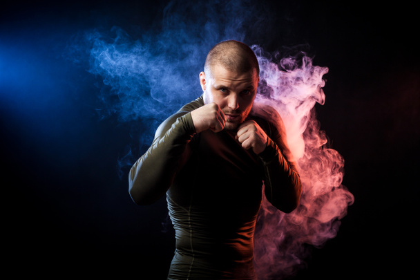 athlete posing against smoke - Foto, imagen