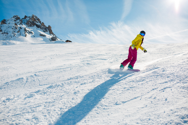 Photo of sports woman snowboarding on snowy slope during day - Photo, Image