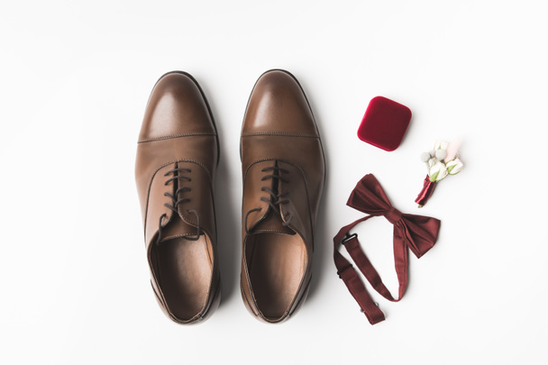 piso con zapatos de novio, ojal, pajarita y joyero aislados en blanco
 - Foto, Imagen