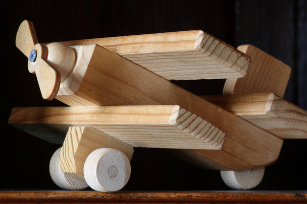 дерев'яний іграшковий літак на столі
 - Фото, зображення