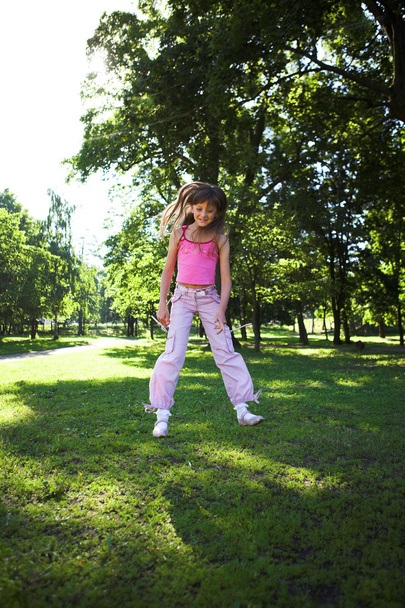 Little girl jumping in park - 写真・画像