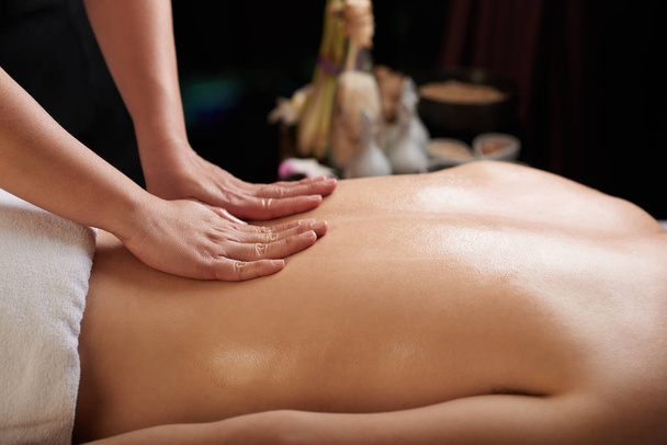Female hands massaging back of male spa salon client - Photo, Image