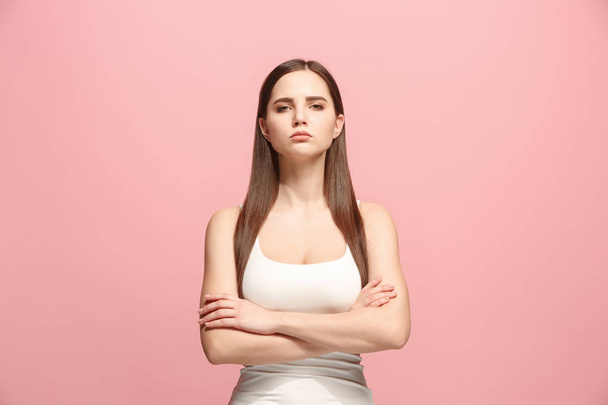 The serious business woman standing and looking at camera against pink background. - 写真・画像