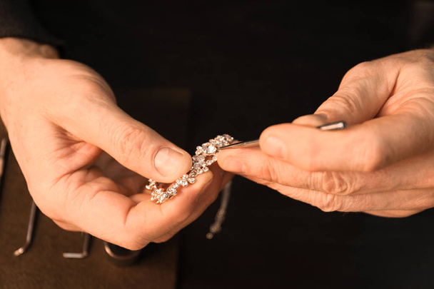 Jeweler repairing bracelet, closeup - 写真・画像