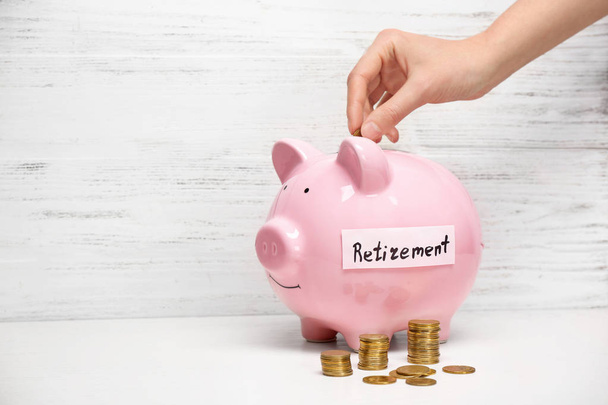 Kumbara etiketli "Emeklilik" içine para koyarak kadın. Emeklilik planlama - Fotoğraf, Görsel