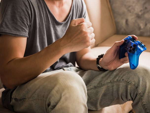 Close up de um jovem jogador jogando o jogo de vídeo com um joystick
 - Foto, Imagem