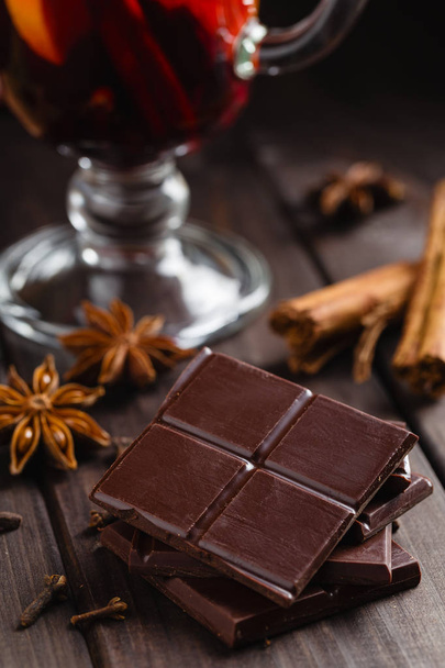 Chopped bitter chocolate with glass of mulled wine and spices  - Foto, Imagem