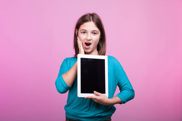 Hermosa joven adolescente con una tableta digital en sus manos
 - Foto, imagen