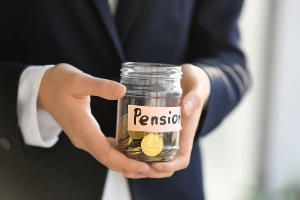 Woman holding glass jar with coins, closeup. Pension planning - Photo, image
