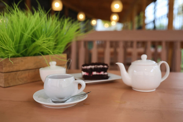 Wasserkocher mit Getränk und Dessert in einem Straßencafé. Tee im Korb - Foto, Bild