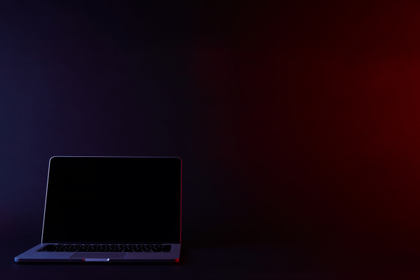 Sammutettu kannettava tietokone tyhjällä näytöllä pimeässä
 - Valokuva, kuva