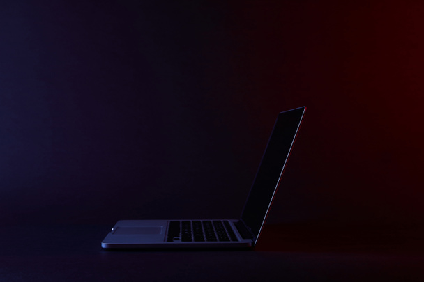 un ordinateur portable ouvert sur une surface sombre
 - Photo, image