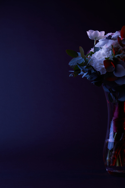 bouquet of different flowers in glass vase on dark - Foto, Bild