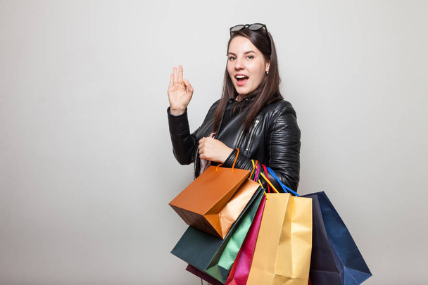Woman Piękne Female pokazuje cztery palcami, niosąc torby na zakupy - Zdjęcie, obraz