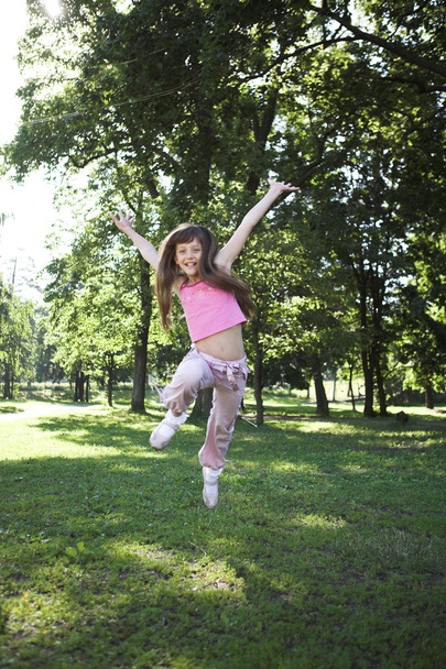 Kleines Mädchen springt in Park - Foto, Bild