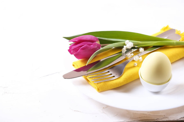Easter laying table appointments, table setting options. Silverware, tableware items with festive decoration. Fork, knife and flowers. Happy easter holiday. - Фото, зображення
