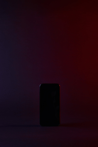 erhöhter Blick auf ein schwarzes Smartphone bei Dunkelheit - Foto, Bild