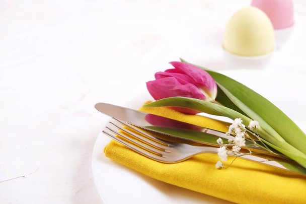 Easter laying table appointments, table setting options. Silverware, tableware items with festive decoration. Fork, knife and flowers. Happy easter holiday. - Foto, Imagen