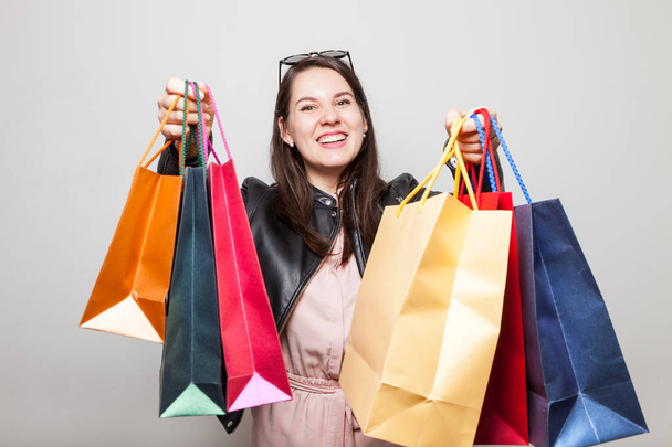 Hermosa risa chica caucásica se extiende bolsas de compras de color
 - Foto, Imagen