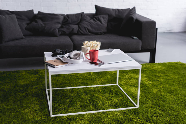 grey sofa and white table with green carpet in living room - Valokuva, kuva