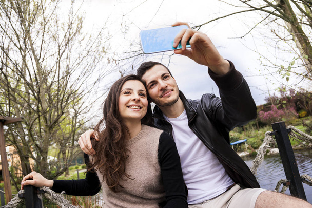 nice couple boyfriends in the park takes a selfie - Foto, Imagen