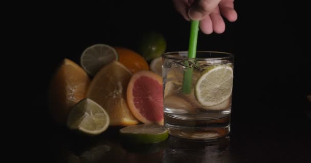 Lime in een glas met soda water, citrusvruchten, zwarte achtergrond. - Video
