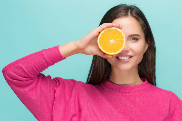 Beautiful womans face with juicy orange - Photo, Image