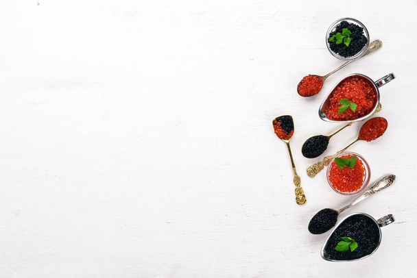 Spoon with black and red caviar on a wooden background. Top view. Free space for text. - Фото, изображение