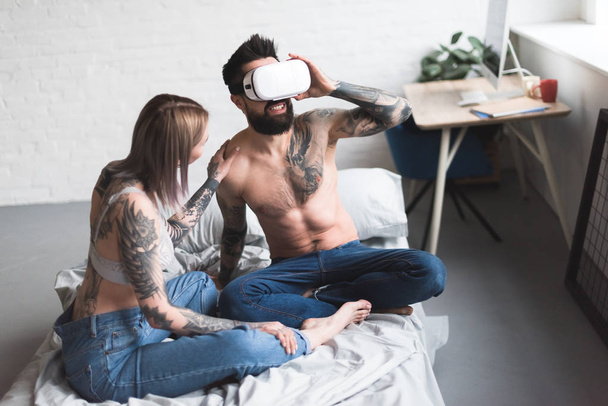 tattooed boyfriend using virtual reality headset at home - Foto, immagini