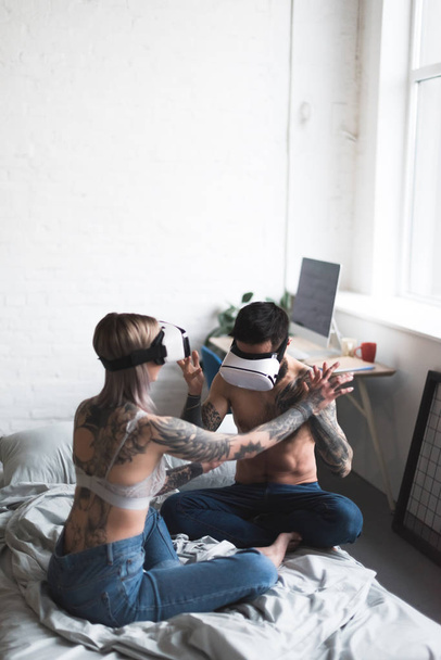 tattooed couple using vr headsets at home - Photo, Image
