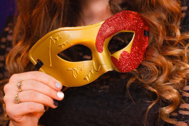 Female hand holds carnival mask closeup - Fotoğraf, Görsel