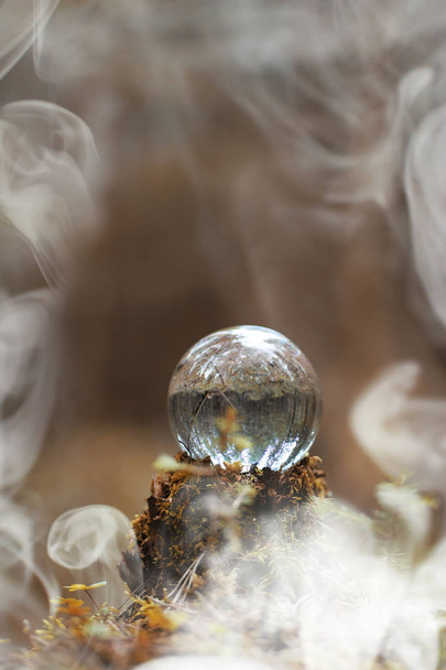 Una bola de cristal en el humo. Un accesorio mágico en el bosque en
 - Foto, Imagen