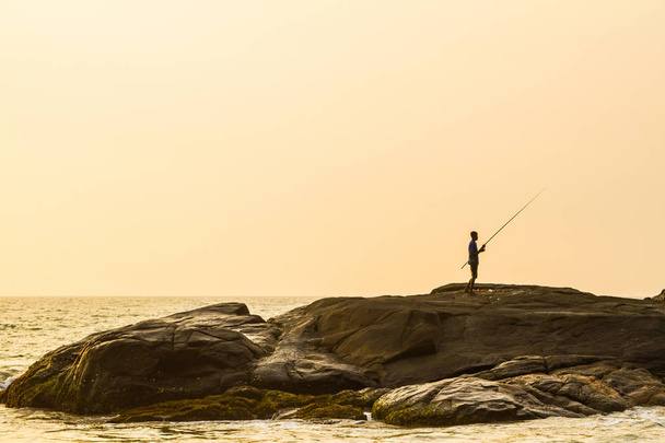 Fisherman at sunset on a tropical beach - Valokuva, kuva