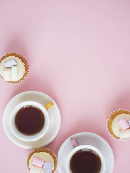 Cups of coffee with cupcakes on pink background - Fotografie, Obrázek