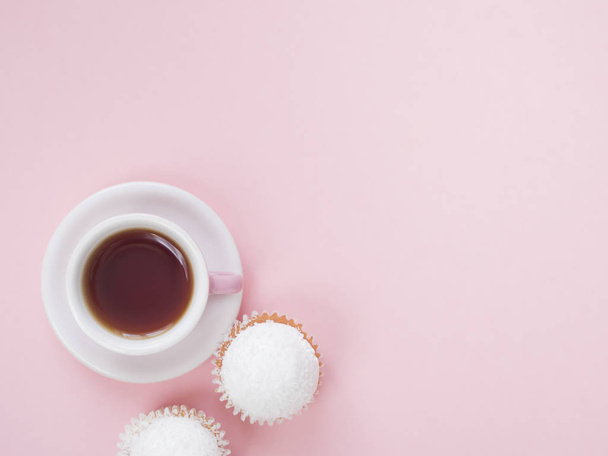 Top view of coffee cup and cupcakes on pink background - Foto, Imagem