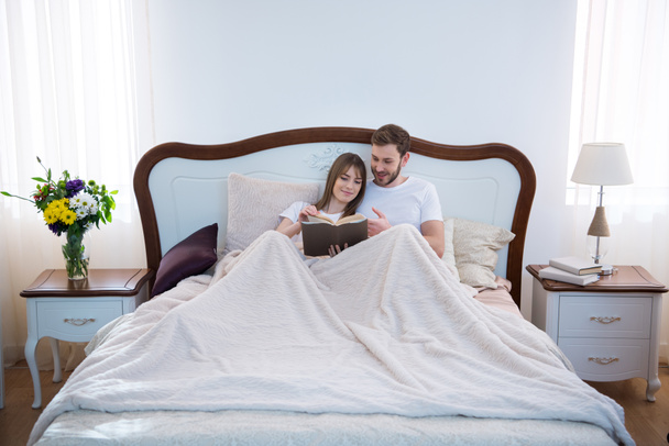 Etunäkymä pari käsittelyssä kirja kodikas moderni makuuhuone
 - Valokuva, kuva