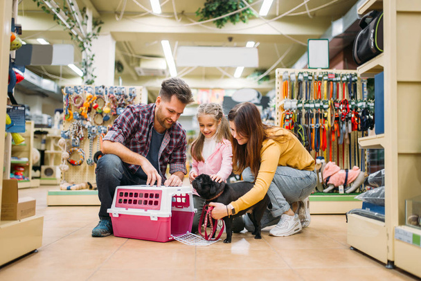 happy family buying supplies for little puppy in pet shop - Photo, image