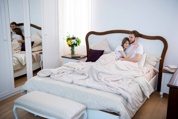 Rahat modern yatak odası yatakta yatan Çift - Fotoğraf, Görsel