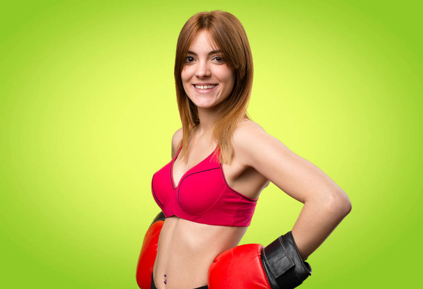 カラフルな背景にボクシング グローブを持つ若いスポーツ女性 - 写真・画像