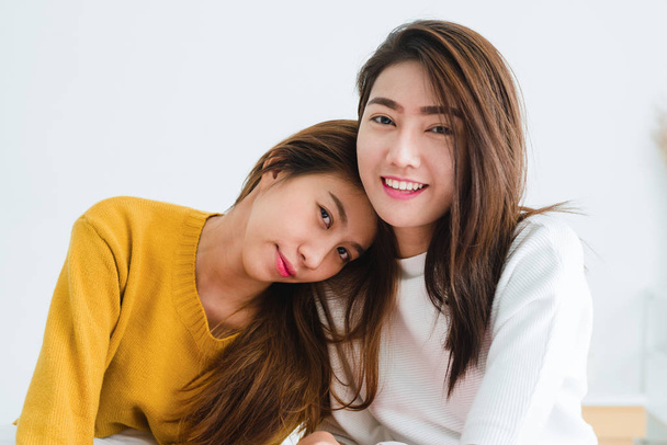 Belle giovani donne asiatiche lesbiche LGBT felice coppia seduta sul letto abbracciare e sorridere insieme in camera da letto a casa. LGBT coppia lesbica insieme indoor concetto. Trascorrere del bel tempo a casa
. - Foto, immagini