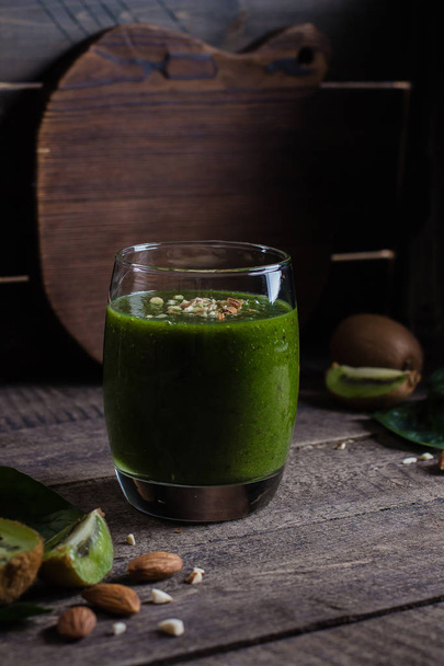 Fresh green smoothies with kiwi and almond on wooden table  - Zdjęcie, obraz
