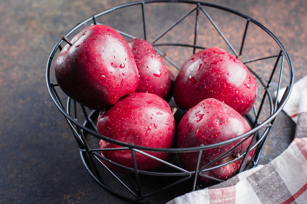 Manzanas rojas maduras frescas en canasta de metal sobre fondo oscuro
 - Foto, Imagen
