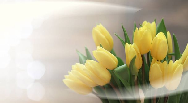  bouquet of yellow tulips in a vase on the floor - Photo, Image